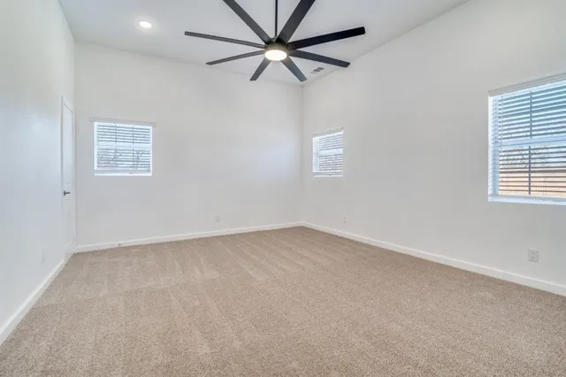 an empty room with a window and a fan