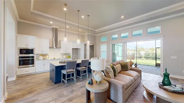 a living room with furniture a large window and kitchen view