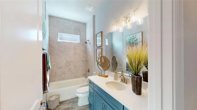 a bathroom with a granite countertop sink a toilet and shower