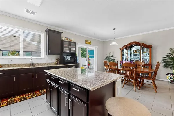 a kitchen with a dining table chairs stainless steel appliances and cabinets