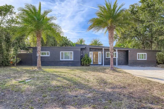 a view of a house with a yard and potted plants