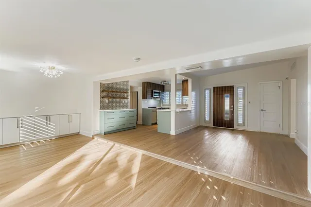 a view of a livingroom with wooden floor and kitchen space with a sink