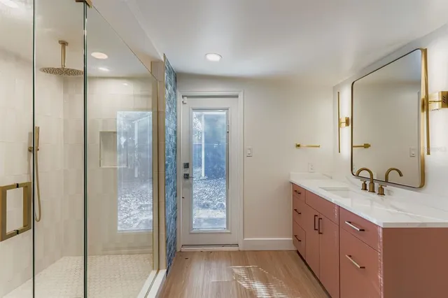 a bathroom with a double vanity sink and mirror with shower