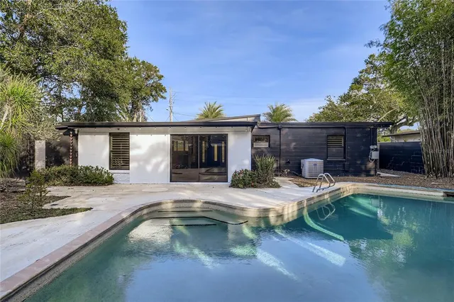 a house view with swimming pool and wooden seating space