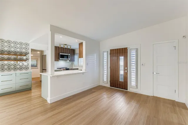 a view of open kitchen with wooden floor and electronic appliances