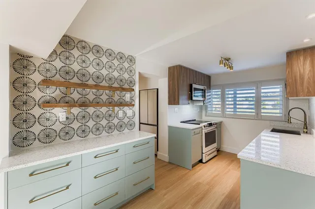 a kitchen with granite countertop white cabinets and stainless steel appliances