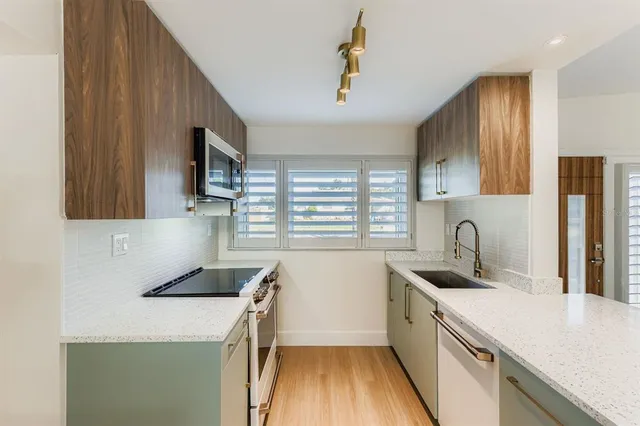 a kitchen with a sink a stove a microwave and a refrigerator