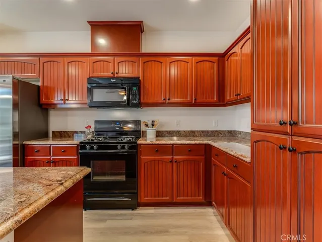 a kitchen with stainless steel appliances granite countertop a stove top oven a sink and dishwasher