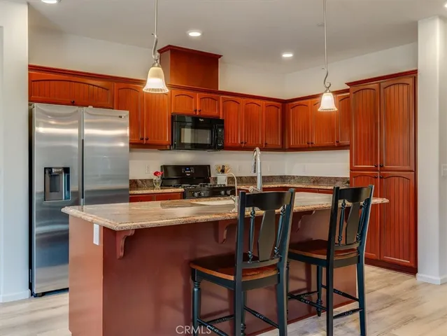 a kitchen with stainless steel appliances granite countertop a sink refrigerator and microwave