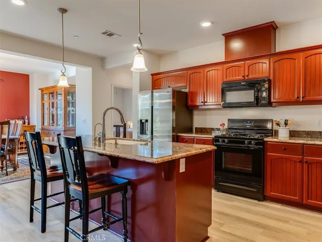 a kitchen with stainless steel appliances granite countertop a stove a sink and a refrigerator