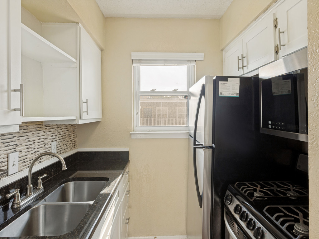 2401 Manor Road, Unit 218 Austin, TX 78722 - Photo 6 of 27 A compact kitchen with sleek appliances and practical counter space, perfect for urban living.