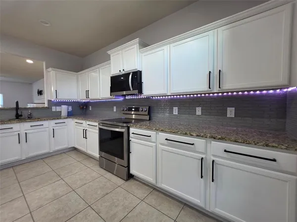 a kitchen with cabinets stainless steel appliances and a sink