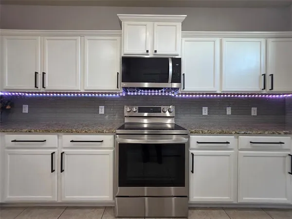 a stove top oven sitting inside of a kitchen