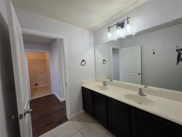 a bathroom with a double vanity sink and a mirror