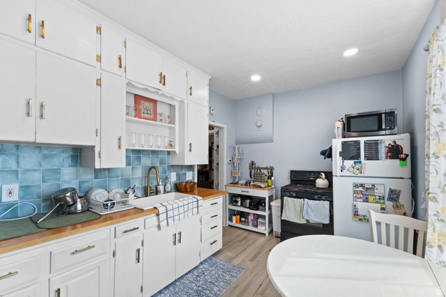 257 200 South Provo, UT 84606 - Photo 23 of 40 Kitchen with freestanding refrigerator, white cabinetry, open shelves, tasteful backsplash, and black gas stove
