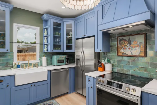 a kitchen with stainless steel appliances a stove a refrigerator and a sink