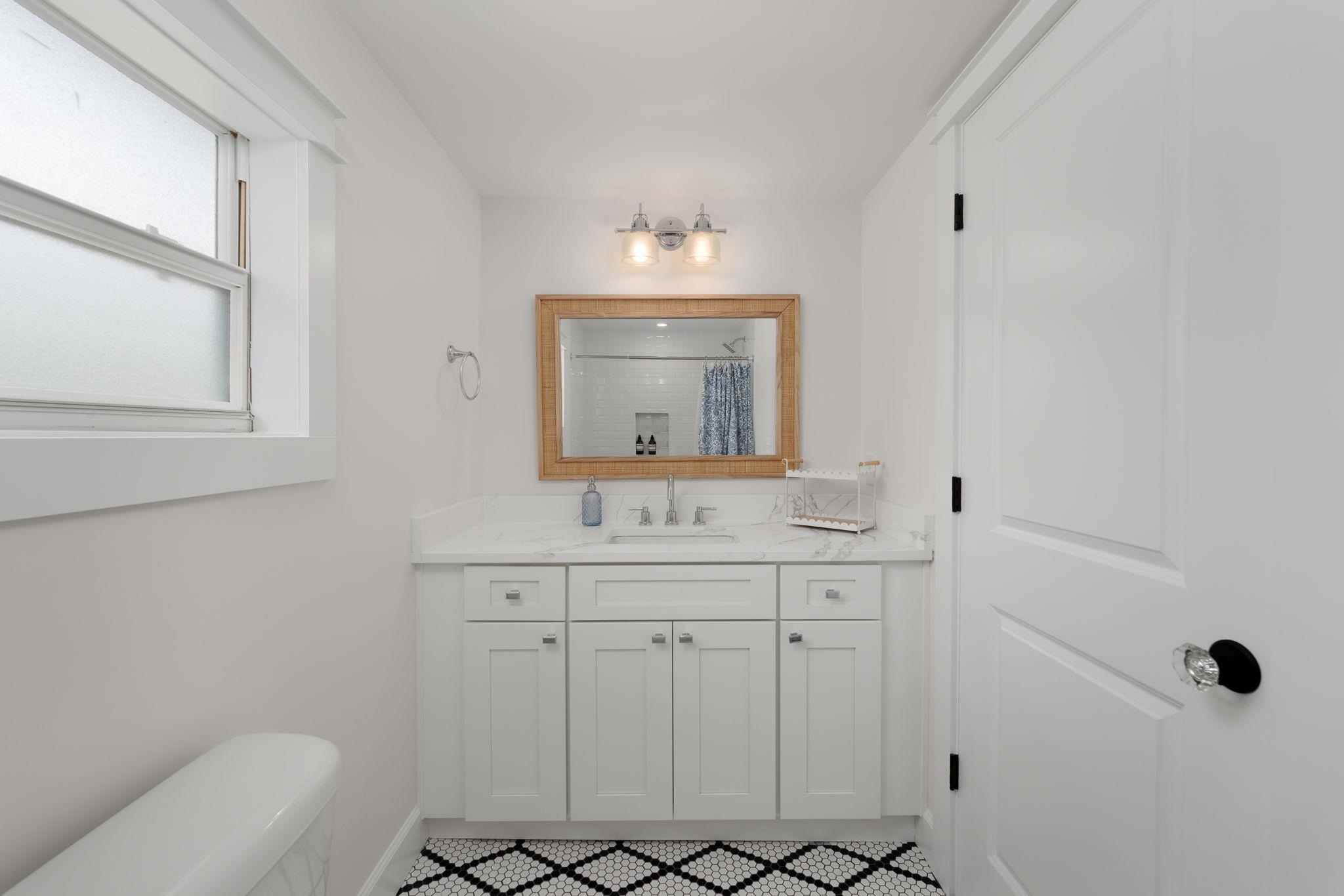 52 Spring Street St. Augustine, FL 32084 - Photo 35 of 45 a bathroom with a sink a toilet and mirror