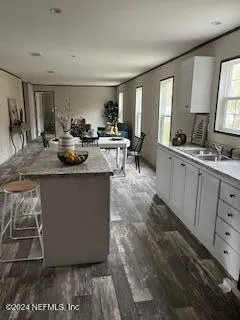 a kitchen with stainless steel appliances granite countertop a sink window and cabinets