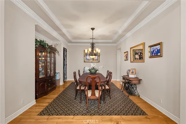 a kitchen with a sink dishwasher a stove and white cabinets with wooden floor