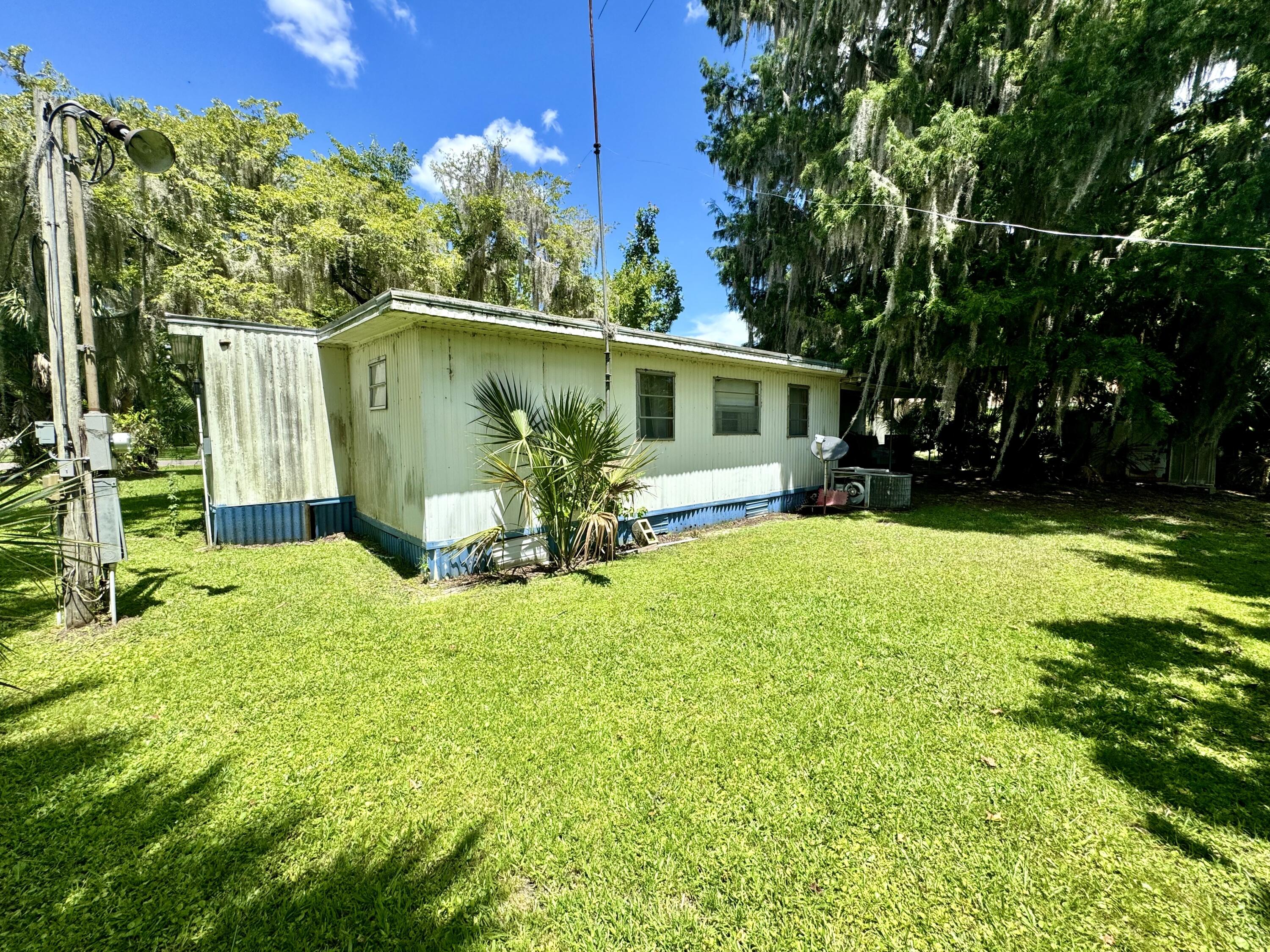 56248 Acorn Road Astor, FL 32102 - Photo 6 of 8 a view of a backyard with table and chairs and potted plants