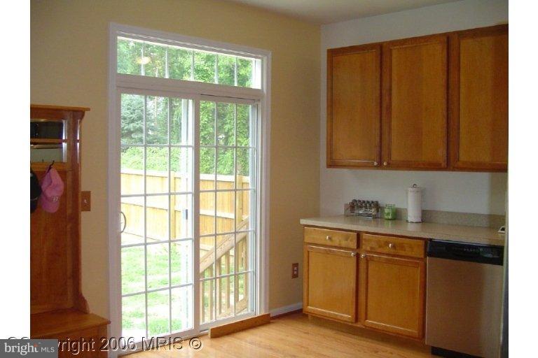a kitchen with stainless steel appliances granite countertop a stove a sink and dishwasher with wooden floor