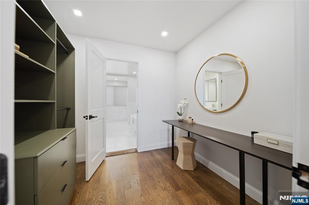 1110 River Road, Unit 102 Edgewater, NJ 07020 - Photo 12 of 18 a room with a mirror and a wooden floors