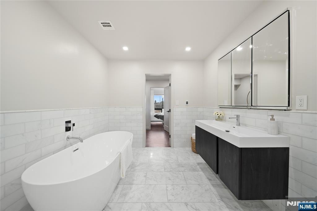 1110 River Road, Unit 102 Edgewater, NJ 07020 - Photo 13 of 18 a spacious bathroom with a double vanity sink and a bathtub