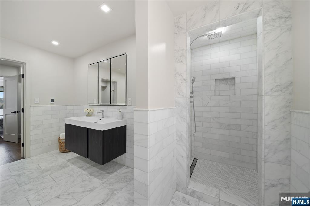 1110 River Road, Unit 102 Edgewater, NJ 07020 - Photo 15 of 18 a bathroom with a sink a mirror and shower