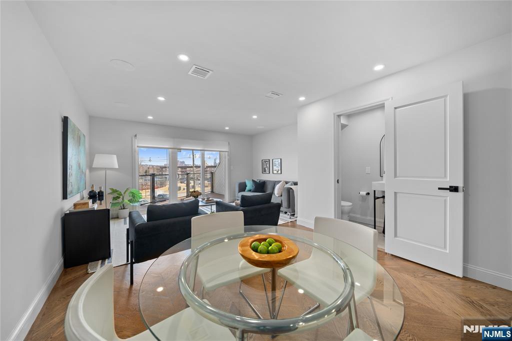 1110 River Road, Unit 102 Edgewater, NJ 07020 - Photo 4 of 18 a living room with dining table a rug and kitchen view