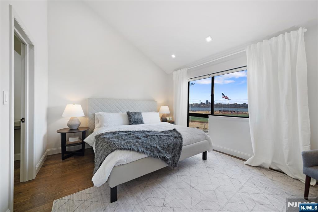 1110 River Road, Unit 102 Edgewater, NJ 07020 - Photo 9 of 18 a spacious bedroom with a bed and a window