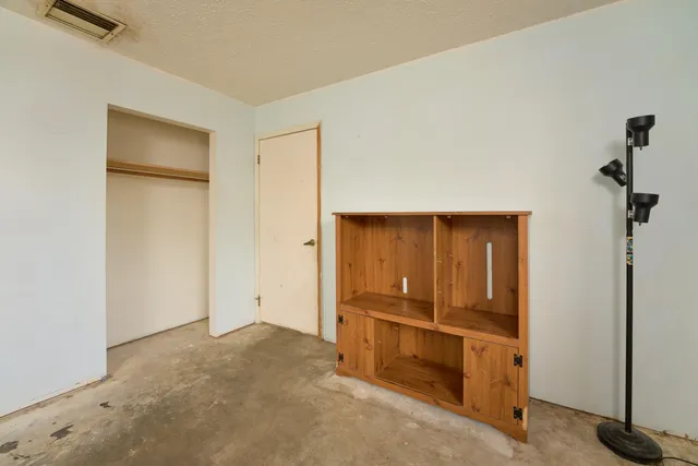 an empty room with windows and closet