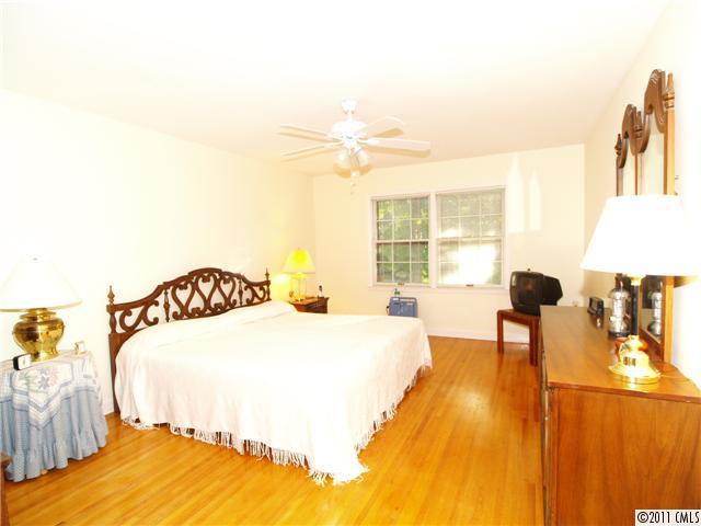 5935 Gate Post Road Charlotte, NC 28211 - Photo 8 of 10 a spacious bedroom with a bed and a chandelier