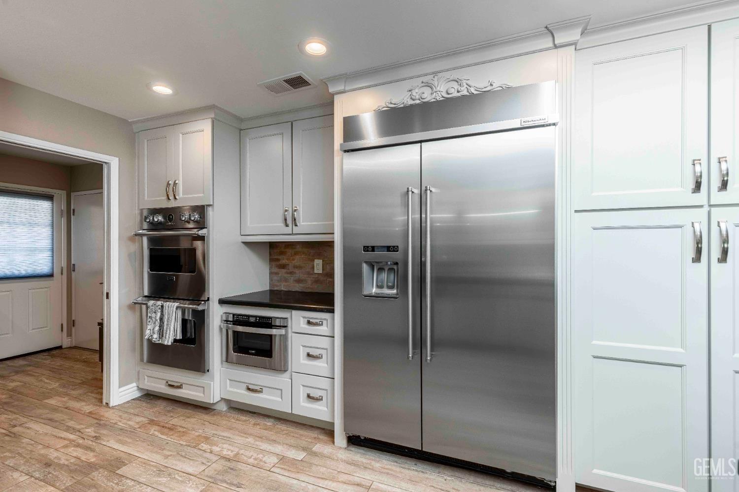 Undisclosed Address Bakersfield, CA 93314 - Photo 17 of 49 a metallic refrigerator freezer and a refrigerator in a kitchen