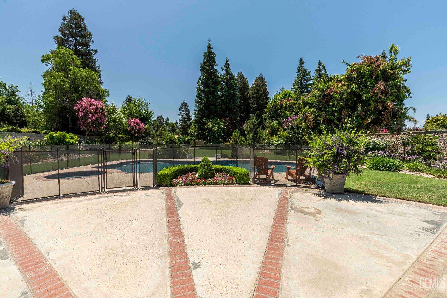 Undisclosed Address Bakersfield, CA 93314 - Photo 29 of 49 a view of a swimming pool with a bench and some trees