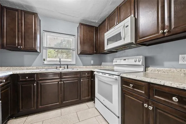 a kitchen with stainless steel appliances granite countertop a sink stove and microwave