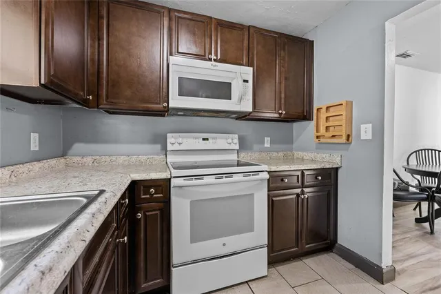 a kitchen with stainless steel appliances granite countertop a stove microwave and sink