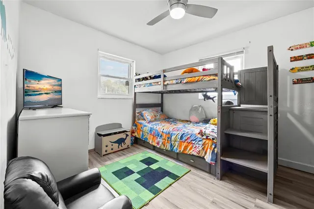 a bedroom with a bed and wooden floor