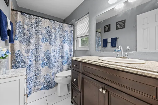 a bathroom with a granite countertop sink a toilet and a mirror