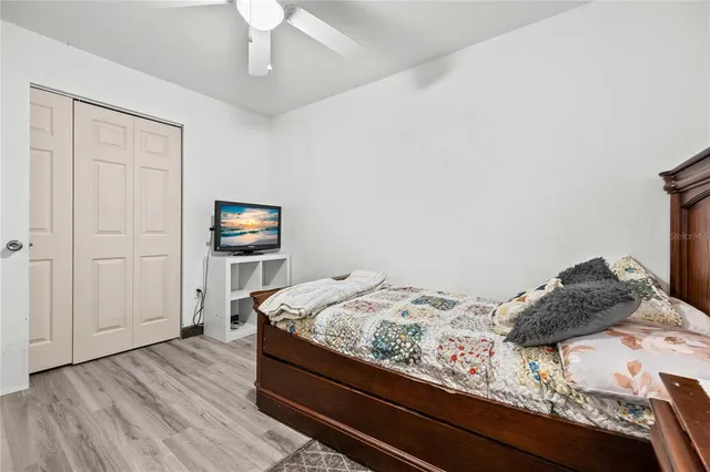 a bedroom with a bed and a lamp on the dresser