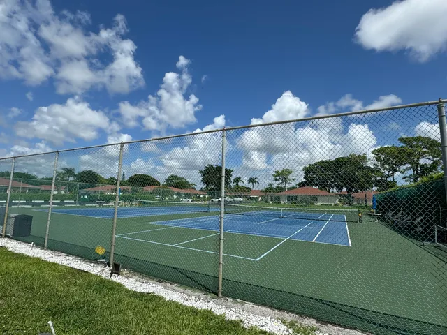 a dining room with wooden floor a chandelier a wooden table and chairs
