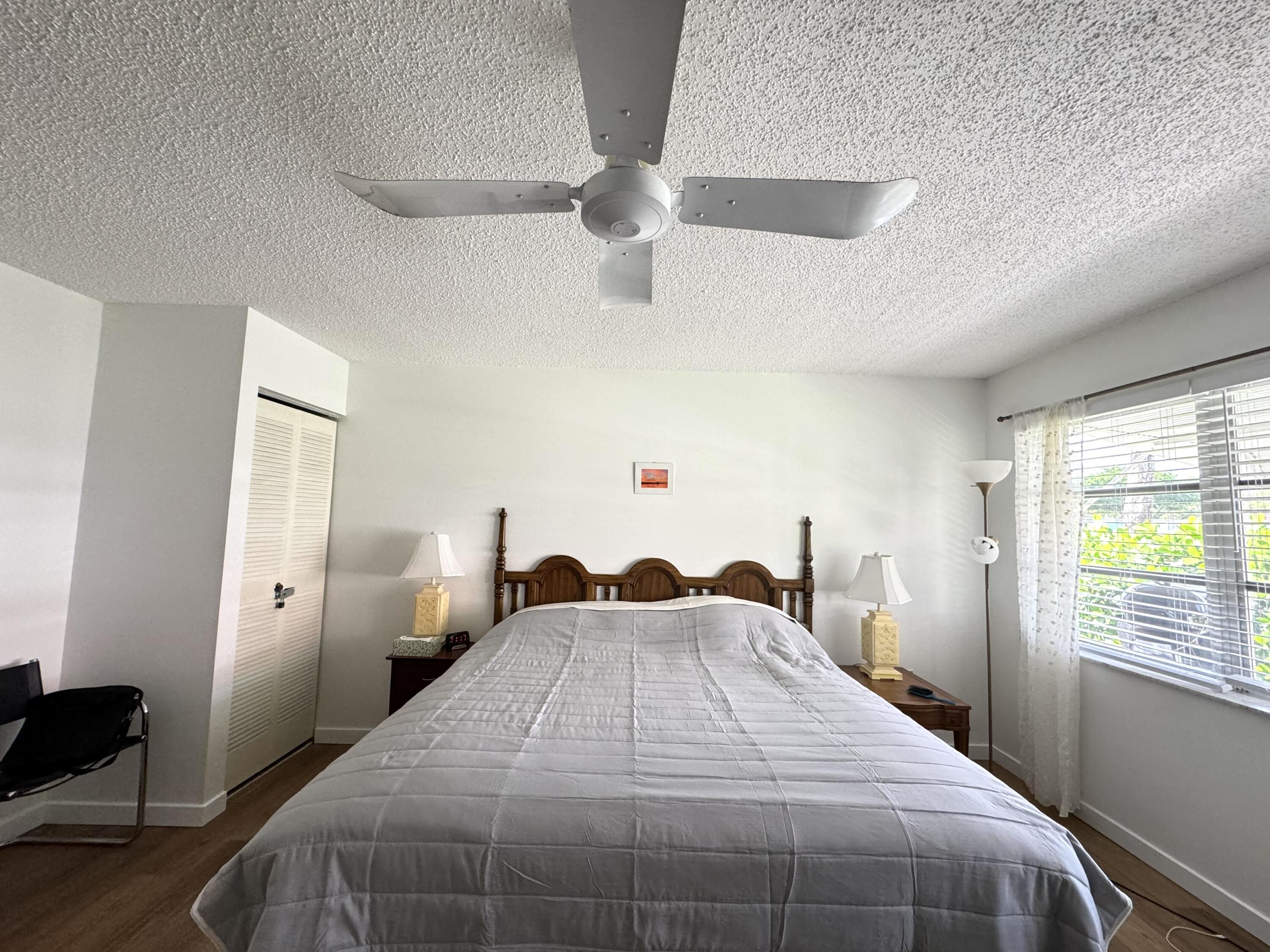 4675 Northwest 3rd Court, Unit B Delray Beach, FL 33445 - Photo 15 of 28 a bed sitting in a bedroom next to a window