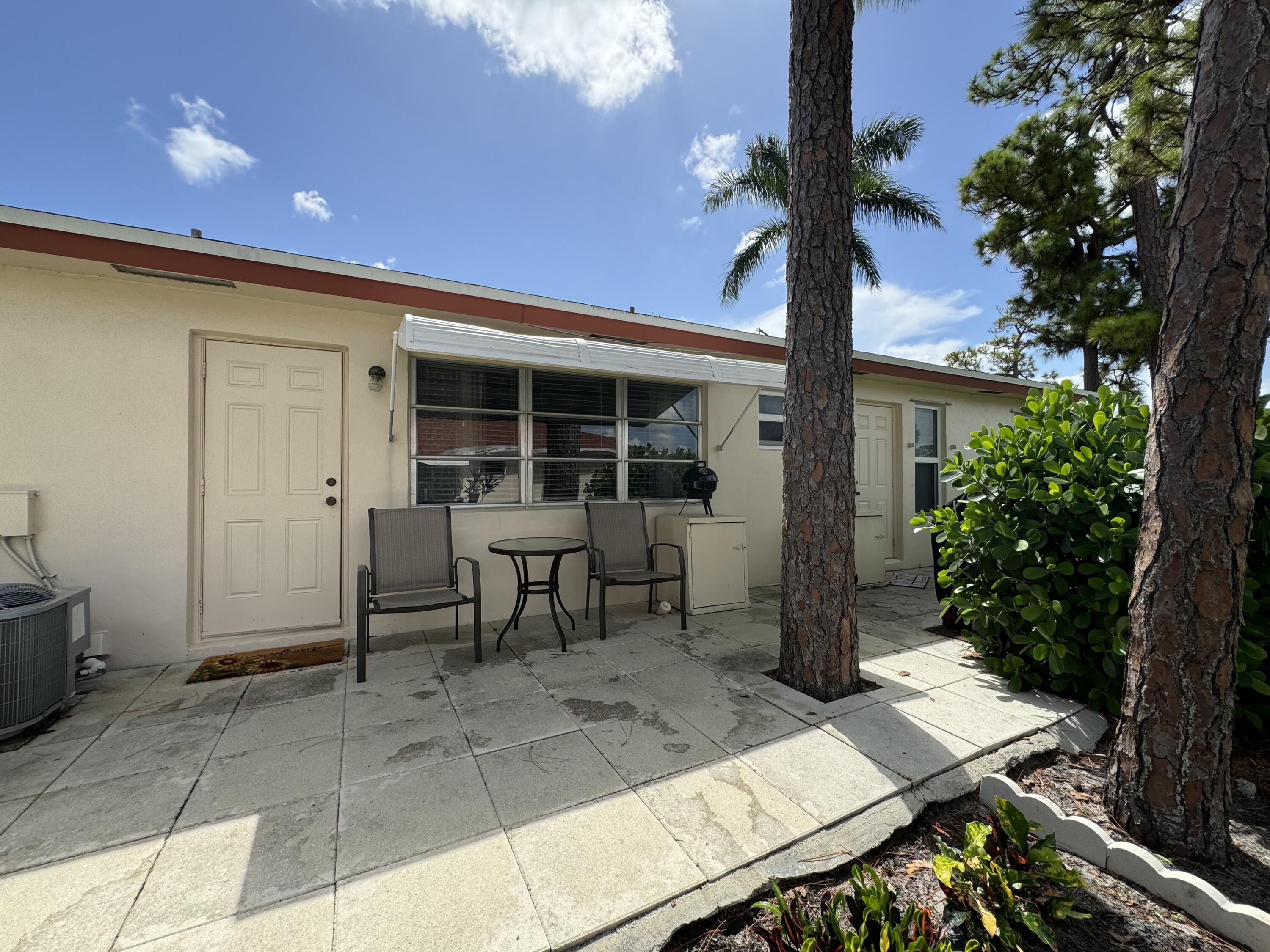 4675 Northwest 3rd Court, Unit B Delray Beach, FL 33445 - Photo 17 of 28 a view of a patio with table and chairs and potted plants