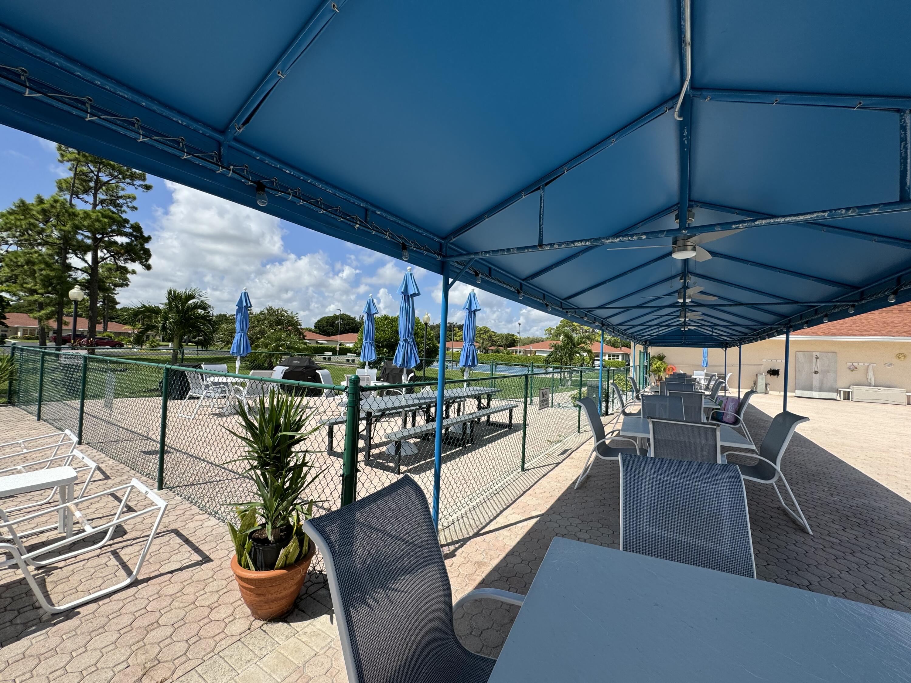 4675 Northwest 3rd Court, Unit B Delray Beach, FL 33445 - Photo 19 of 28 a view of a patio with couches table and chairs