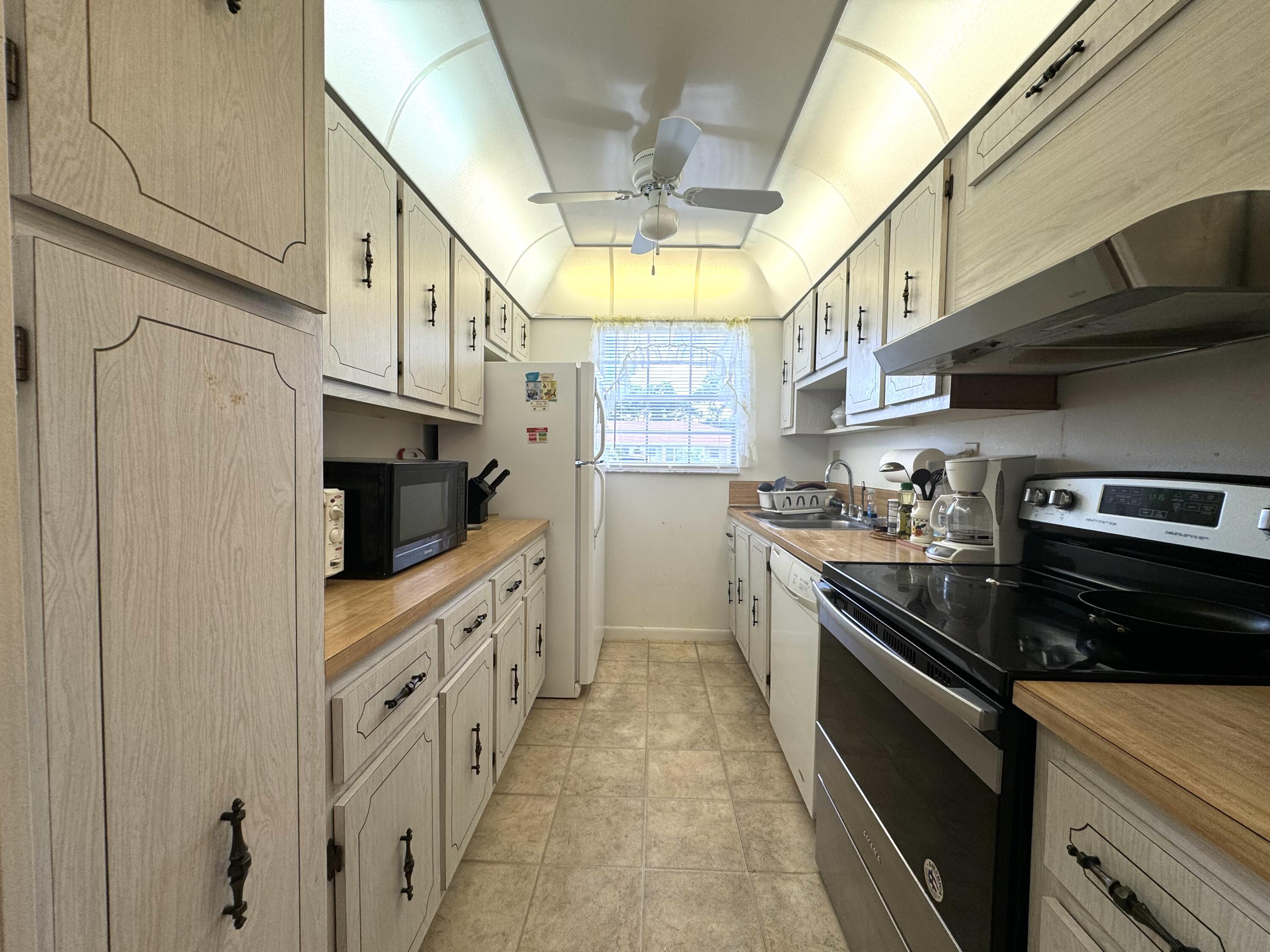 4675 Northwest 3rd Court, Unit B Delray Beach, FL 33445 - Photo 8 of 28 a kitchen with stainless steel appliances granite countertop a stove and a refrigerator