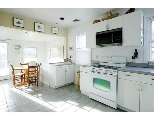 a kitchen with stainless steel appliances a stove microwave and white cabinets