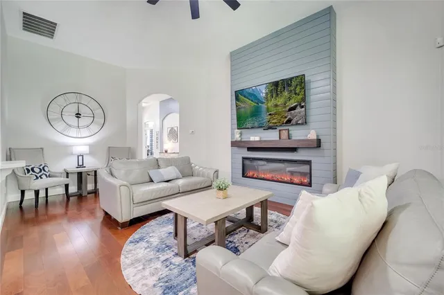a living room with furniture a wooden floor and a fireplace