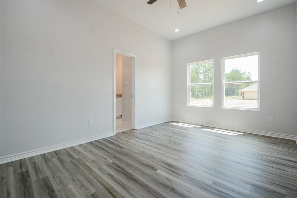 2352 Cedar Place Drive Conroe, TX 77306 - Photo 17 of 26 an empty room with wooden floor and windows