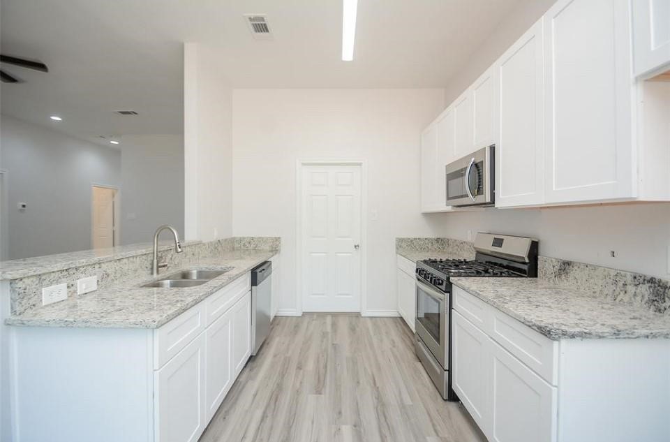 2352 Cedar Place Drive Conroe, TX 77306 - Photo 5 of 26 a kitchen with granite countertop a sink stove and cabinets