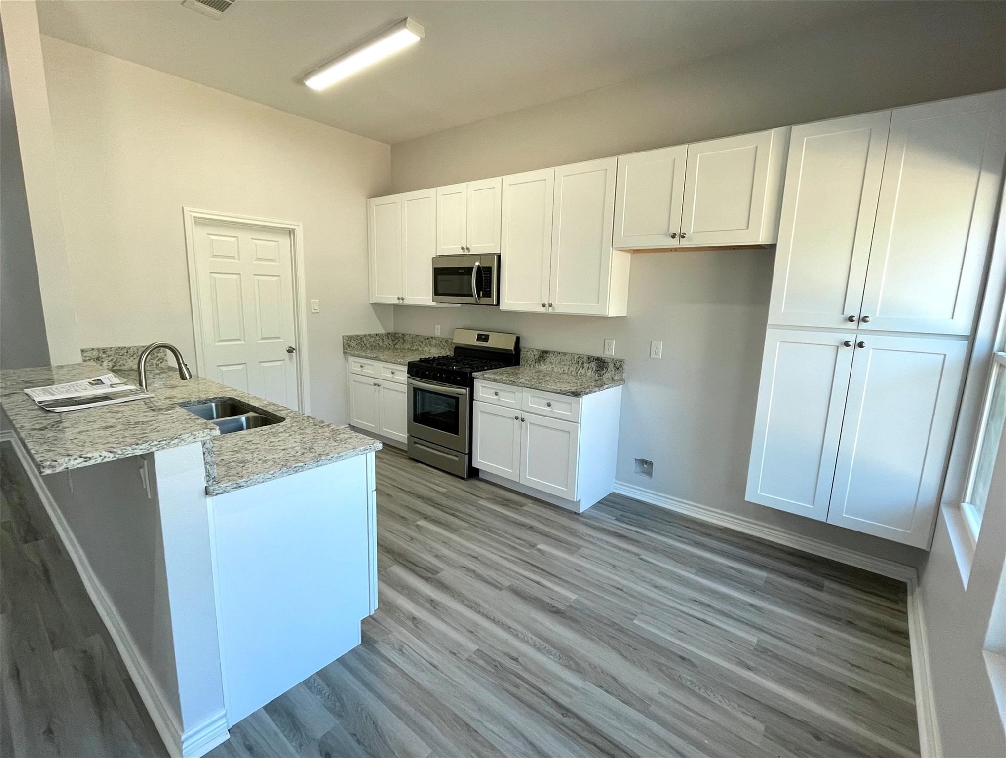 2352 Cedar Place Drive Conroe, TX 77306 - Photo 7 of 26 a kitchen with granite countertop a sink stove and refrigerator