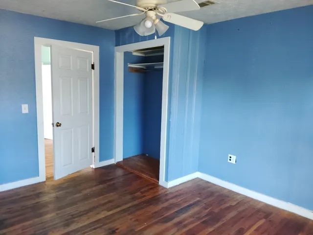 a view of an empty room with wooden floor